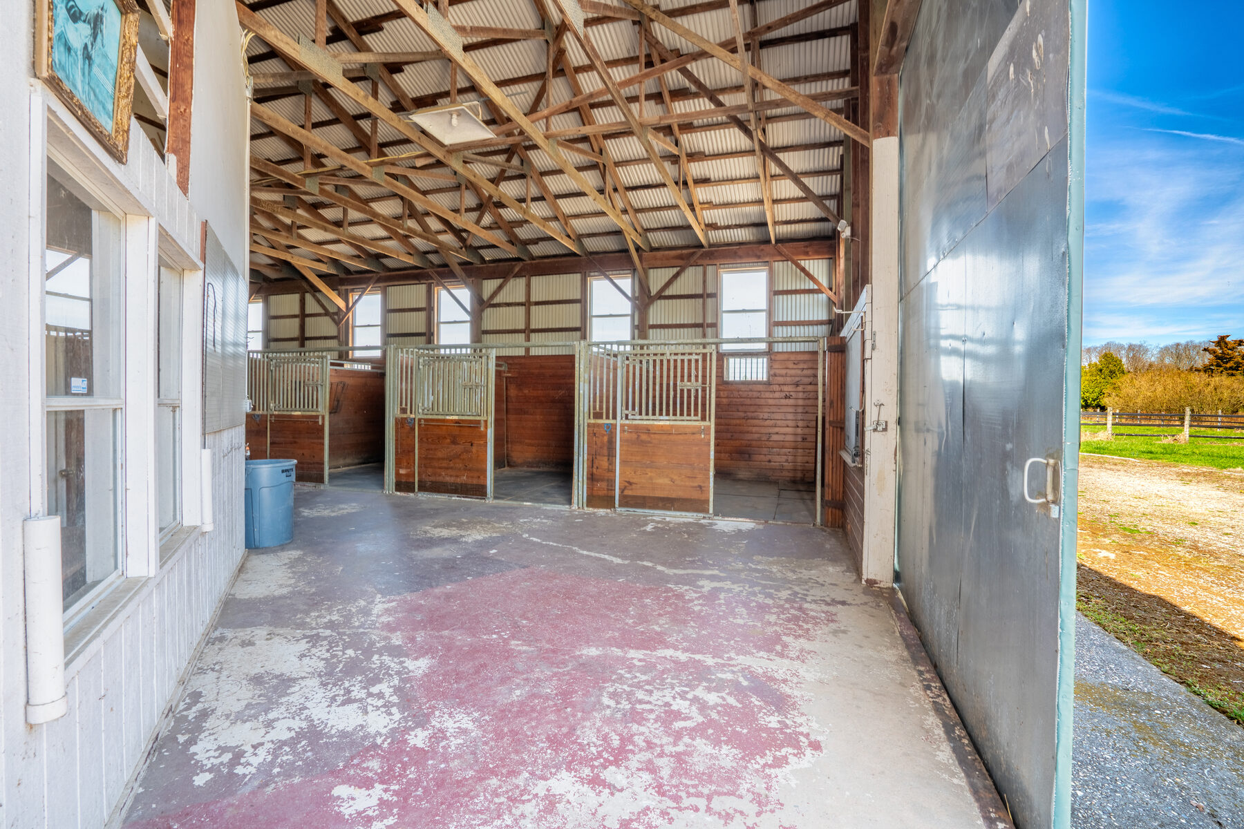 Side row of horse stalls with the round window above